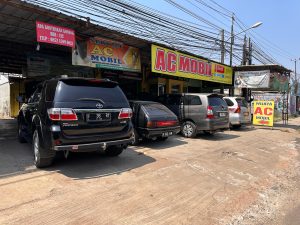 Kompresor AC mobil di ruang mesin yang perlu oli pelumas