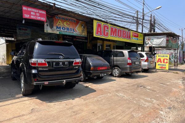 Kompresor AC mobil di ruang mesin yang perlu oli pelumas