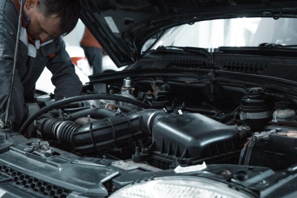 Mekanik memeriksa mesin mobil saat uji kebocoran freon AC